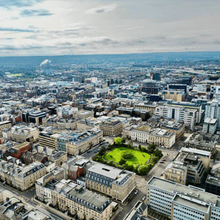 Aerial view of Glasgow city centre, showing a mix of historic and modern architecture with a prominent green space.