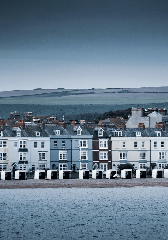 Georgian seafront and beach huts along Weymouth Central Beach, Dorset, England, part of the Jurassic Coast UNESCO World Heritage Site.
