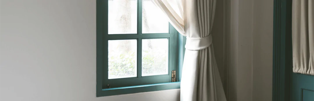 turquoise window frame with white curtain