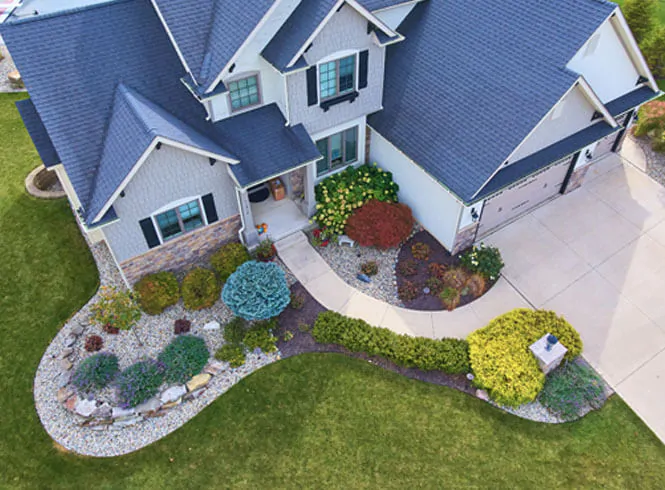 birdseye view outside traditional house with beautiful summer landscaping