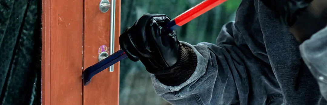 burglar breaking into house using a scrowbar on the door