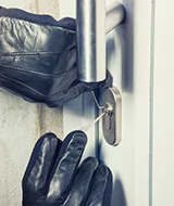 burglar picking the lock of door to break into house