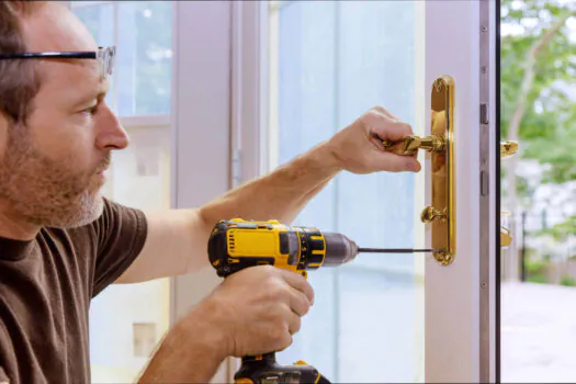 locksmith using drill to fit new locks and handles