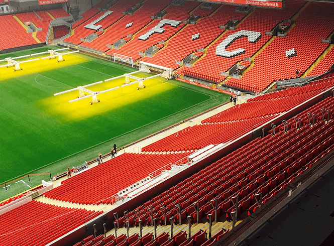 Aerial view of Anfield Stadium, featuring red seats, illuminated pitch, and "LFC" displayed on the stands.