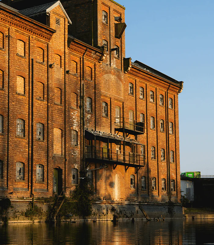 a large brick building sitting next to a body of water
